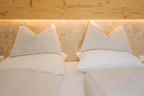 two white pillows sitting on top of a bed at Appartements Bergheim in Hirschbichl