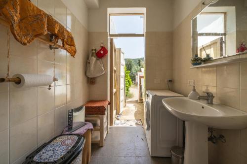 uma pequena casa de banho com um lavatório e uma janela em Olive Tent - In Our Garden em Capitana