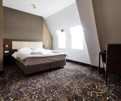 sypialnia z dużym łóżkiem i oknem w obiekcie Amsterdam Lake Hotel w mieście Badhoevedorp