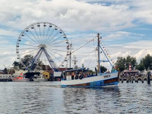 a boat in the water next to a ferris wheel at Ferienanlage Kieferneck in Freest