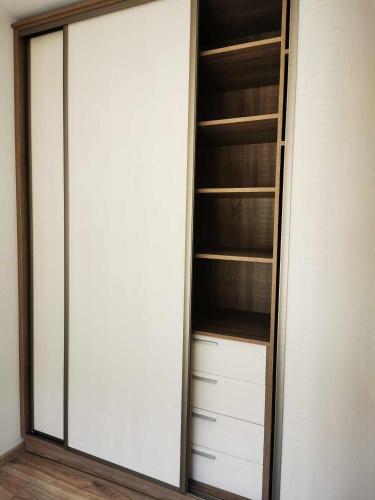 a closet with white cabinets and a glass door at Apartament nad Jeziorem w Olecku in Olecko