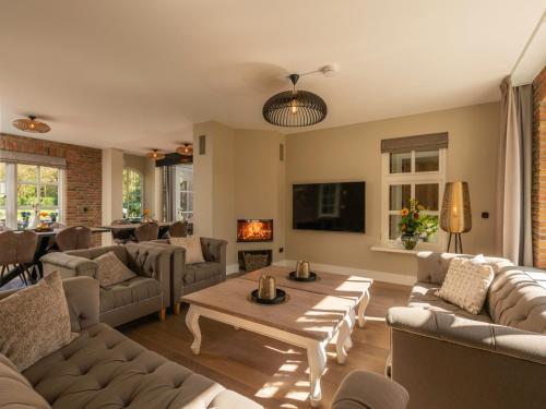 a living room with couches and a table at Holiday Home Het Landhuis by Interhome in Losser