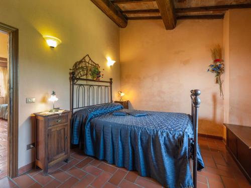 a bedroom with a bed with a blue bedspread at Holiday Home Le Calle by Interhome in Cinigiano