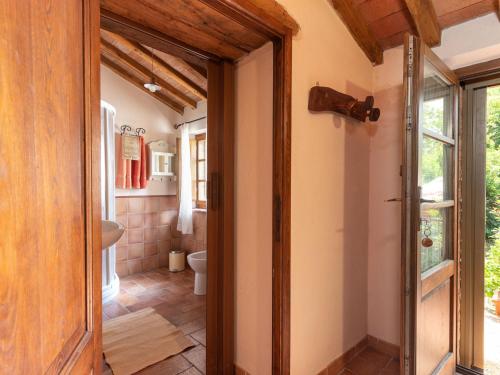 a bathroom with a toilet and a sink and a door at Holiday Home Olinto by Interhome in Cinigiano