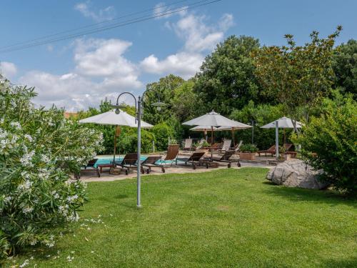 a yard with chairs and umbrellas and a pool at Holiday Home Olinto by Interhome in Cinigiano
