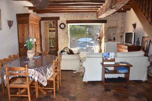 uma sala de estar com uma mesa e um sofá em Les Volets Bleus em Provins