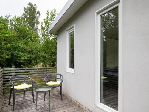 2 sedie e un tavolo in vetro su un portico di Holiday Home Solbacken by Interhome ad Alingsås