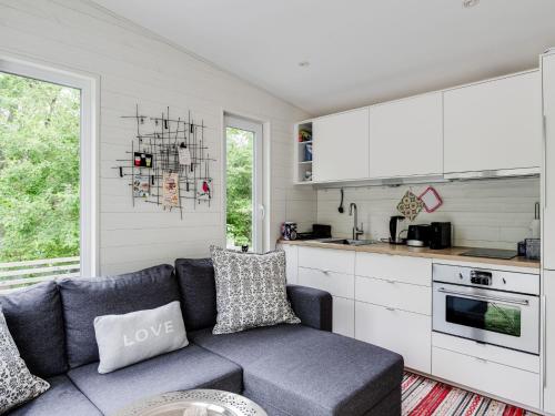 a living room with a couch and a kitchen at Holiday Home Solbacken by Interhome in Alingsås