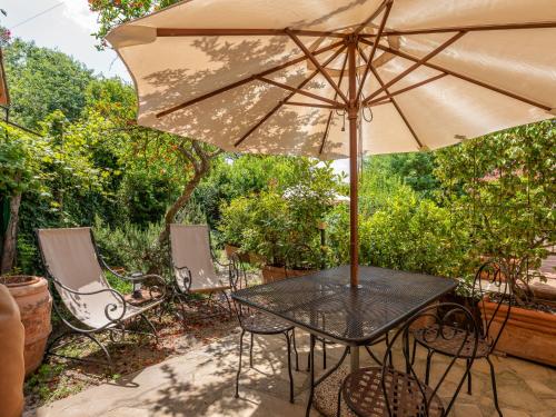a table and chairs with an umbrella on a patio at Holiday Home Carola by Interhome in Cinigiano