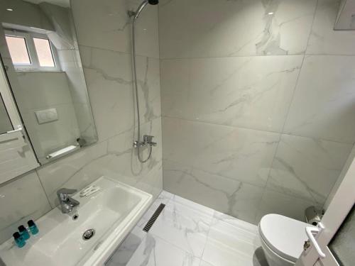 biała łazienka z umywalką i toaletą w obiekcie Saranda Rooms w Sarandzie