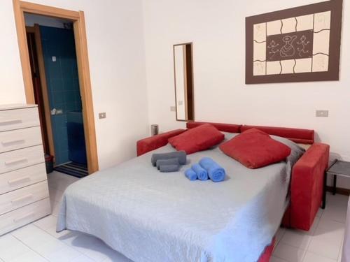 um quarto com uma cama grande com almofadas vermelhas e azuis em GardenHouse em Cagliari