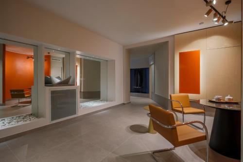 a living room with a table and chairs and mirrors at Hotel Velino in Avezzano