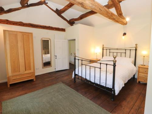 a bedroom with a bed and a wooden floor at Roger Pot in Sedbergh