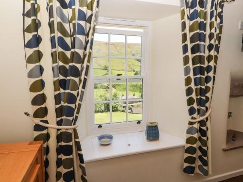 a window with black and white curtains in a room at Roger Pot in Sedbergh