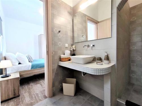 a bathroom with a sink and a bed and a mirror at Studio Elpida Santorini in Vóthon