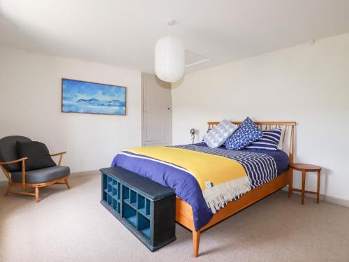 a bedroom with a king sized bed and a chair at Greenbank in Perranporth