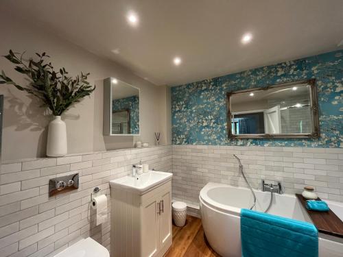 a bathroom with a tub and a toilet and a sink at Willow Brook in Blandford Forum
