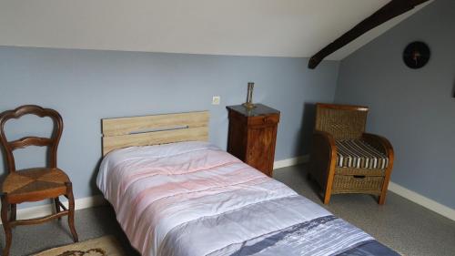 1 dormitorio con 1 cama, vestidor y silla en Chez Hervé, en Saint-Mars-sur-Colmont