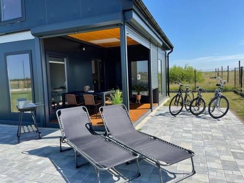 twee stoelen en fietsen op een patio met een huis bij Domki letniskowe Bali in Jezierzany