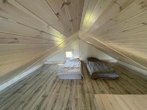 een grote houten kamer met een bed in het midden bij Domki letniskowe Bali in Jezierzany