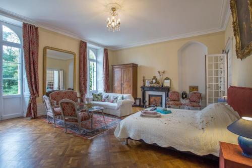 uma sala de estar com uma cama, uma mesa e cadeiras em La Maison de maître em Fontenay-le-Comte