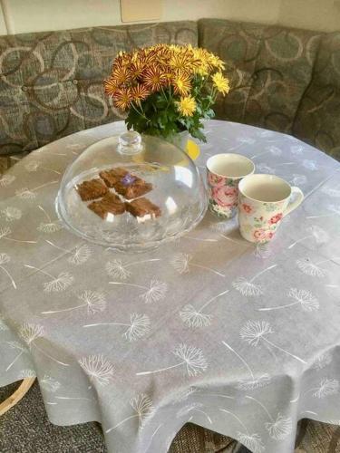 a table with a glass plate and two cups on it at Park Gate, Colyton, farm,near beaches-‘Annie’ in Colyton
