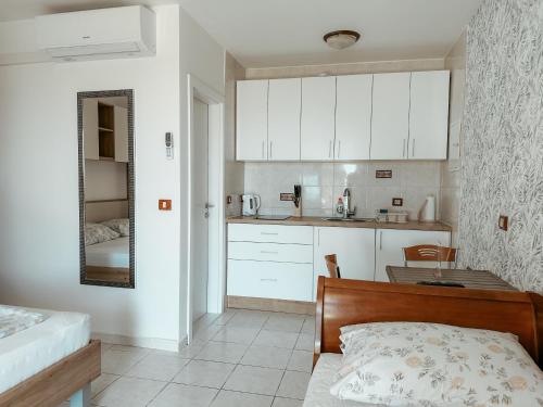 a kitchen with white cabinets and a bed in a room at Villa Božica - sea view stone villa with free parking in Makarska