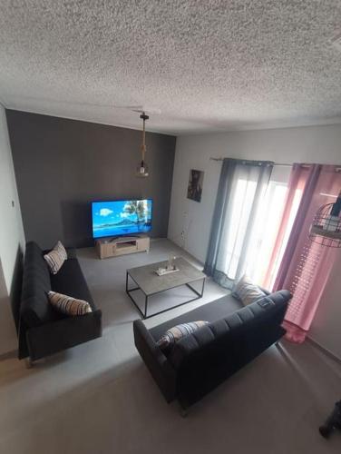 a living room with a couch and a tv at House Of Diamond in Kírra