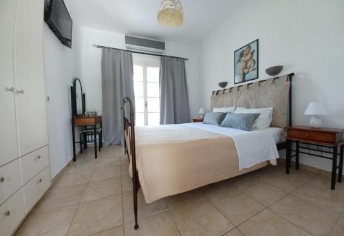 1 dormitorio con 1 cama grande y TV en Babis Apartments & Studios Iremia, en Acharavi