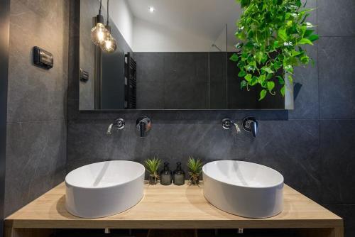 a bathroom with two white sinks on a wooden counter at Villa Olea by IstriaLux in Šumber