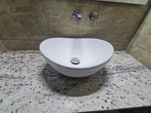 a bathroom with a white sink on a counter at The Nalanda Heritage in Rājgīr