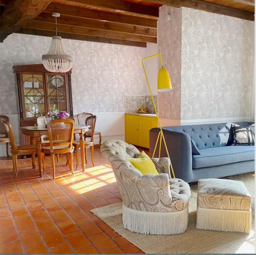 un salon avec un canapé bleu et une salle à manger dans l'établissement Petite Maison de Gouyas, à Montagrier