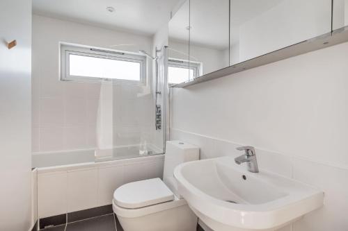 a white bathroom with a sink and a toilet at The Billy Shed in Bridport