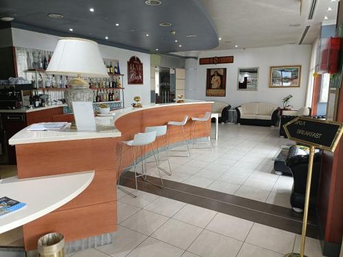 un restaurante con bar con taburetes en una habitación en Green Hotel Ninfa en Avigliana