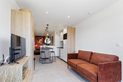 un salon avec un canapé et une cuisine dans l'établissement Geisha Port Nature coursive, au Cap d'Agde