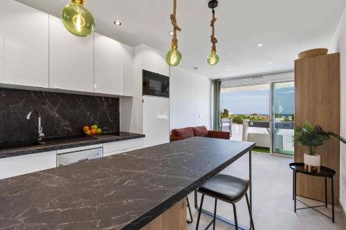 une cuisine avec un comptoir noir et une table dans l'établissement Geisha Port Nature coursive, au Cap d'Agde