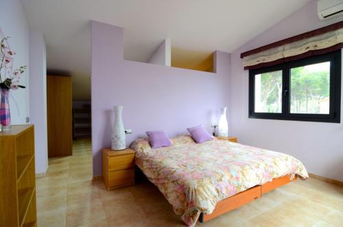 パルスにあるCasa Ametllersのベッドルーム1室(紫色の枕が付くベッド1台、窓付)
