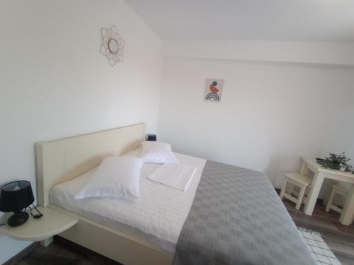 a bedroom with a bed with white sheets and pillows at Pestele Ca Odinioară in Murighiol
