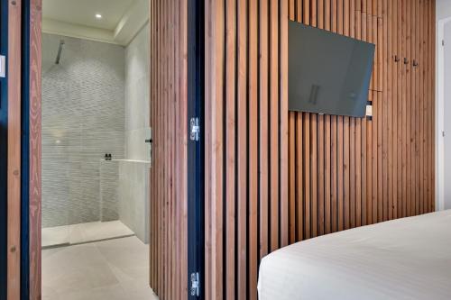 a bedroom with a tv on a wooden wall at Harmony villa - Ioannina castle in Ioannina