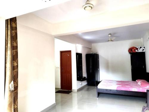 a bedroom with a bed and a door in it at #vrabode 1BHK apartment w Pool at Seacoast Retreat Varca in Talaulim