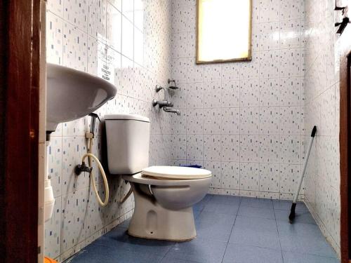 a bathroom with a toilet and a sink at #vrabode 1BHK apartment w Pool at Seacoast Retreat Varca in Talaulim
