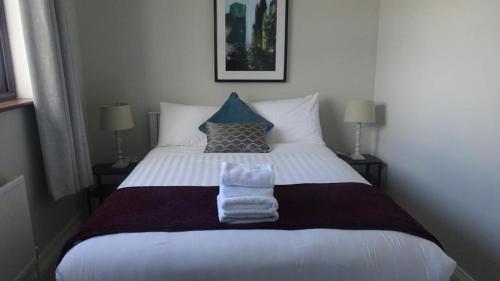 sypialnia z dużym łóżkiem z ręcznikami w obiekcie Ger's Lodging w Galway