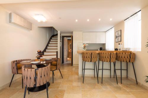 a kitchen and living room with a table and chairs at Hôtel L'Incomparable Aix-Les-Bains in Tresserves