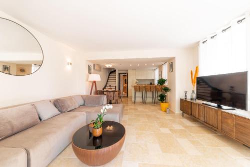 a living room with a couch and a table at Hôtel L'Incomparable Aix-Les-Bains in Tresserves