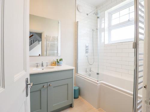 a bathroom with a sink and a tub and a shower at 16 Garfield Road in Felixstowe