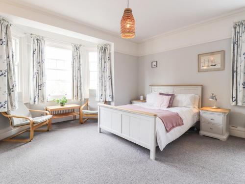 a white bedroom with a bed and a desk and chairs at 16 Garfield Road in Felixstowe