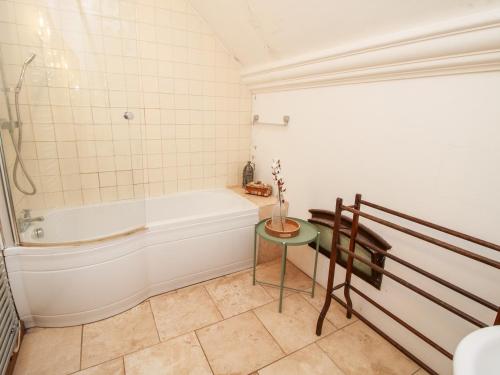 a bathroom with a bath tub and a table at Talbot Lodge in Stafford