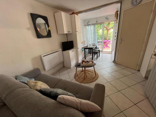 un salon avec un canapé et une table dans l'établissement Appartement en rez-de-chaussée avec terrasse à Narbonne Plage 4MED301, à Narbonne-Plage