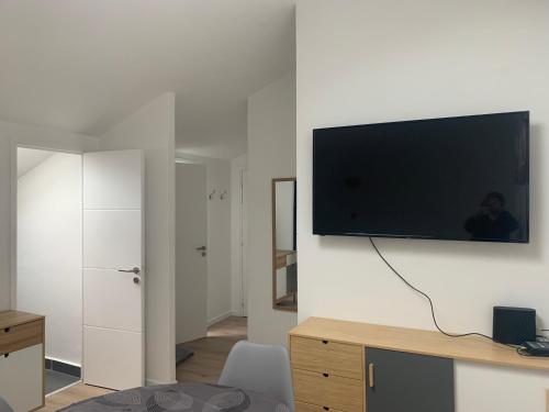 sala de estar con TV de pantalla plana en la pared en appartement centre Vannes en Vannes