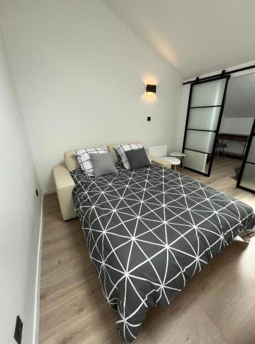 - une chambre avec un lit noir et blanc et un canapé dans l'établissement appartement centre Vannes, à Vannes